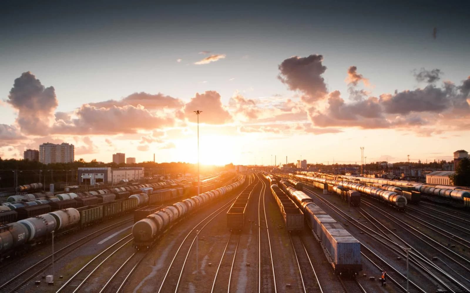 A railway freight yard lit by a colourful sunset